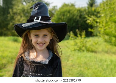 Halloween girl going to collect candy. Trick-or-treating. Guising. Jack-o-lantern. Child in carnival costume witch outdoors. Celebrate halloween. Girl in forest smiling and holding basket of sweets - Shutterstock ID 2213391779