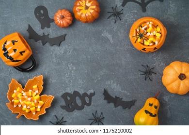 Halloween Holiday Background With Jack O Lantern Pumpkin, Candy Corn And Decorations On Blackboard. View From Above. Flat Lay