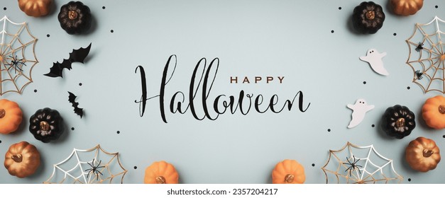 Halloween holiday background with party decorations from  pumpkins, bats, ghosts, spider webs on blue top view. Greeting card with text inscription Happy Halloween in banner format.
 - Powered by Shutterstock