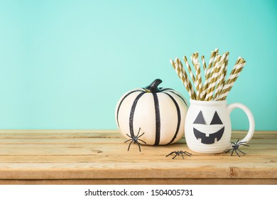 Halloween Holiday Concept With Jack O Lantern Cup And White Pumpkin Decor On Wooden Table