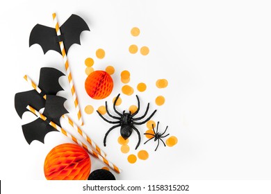 Halloween Holiday Decorations. Striped Straws With Paper Bats And Confetti , Spiders  On White Background. Flat Lay, Top View 