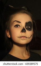 Halloween, holidays, masquerade concept - the portrait of young little beautiful girl with skull makeup on black background. Halloween, face-art, skull make up concept.

