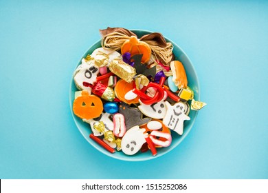 Halloween Jack o Lantern candy bowl with candy and halloween cookies Trick or Treat on blue background  - Powered by Shutterstock