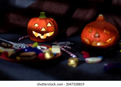 Halloween Jack o Lantern candy holder with scattered candy on rustic wood background - Powered by Shutterstock