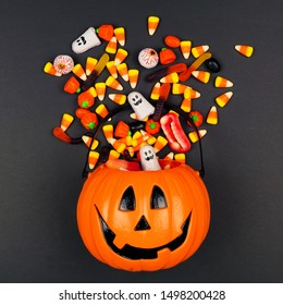 Halloween Jack o Lantern pail with spilling candy, top view on a black background - Powered by Shutterstock