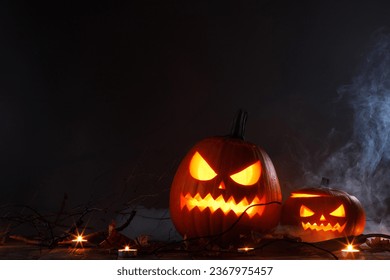 Halloween Jack O Lantern pumpkins and burning candles in mist traditional decoration - Powered by Shutterstock