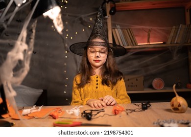 Halloween Kids Craft Preparations. Girl Child Doing Autumn Crafts At Home In The Night. Halloween Children Party Concept.