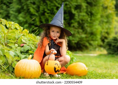 Halloween Kids. Portrait Happy Girl In Witch Costume, Black Hat On Scary Merry Holiday. Child With Pumpkin, Jack O Lantern, Basket Candy Sweet, Scaring Boo