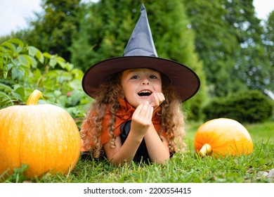 Halloween Kids. Portrait Happy Girl In Witch Costume, Black Hat On Scary Merry Holiday. Child With Pumpkin, Jack O Lantern, Basket Candy Sweet, Scaring Boo