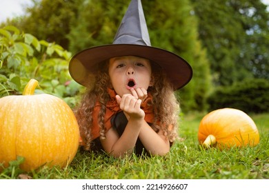 Halloween Kids. Portrait Happy Girl In Witch Costume, Black Hat On Scary Merry Holiday. Child With Pumpkin, Jack O Lantern, Basket Candy Sweet, Scaring Boo