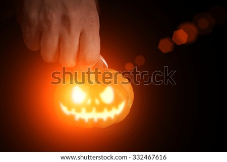 Halloween mask on a pumpkin in hands