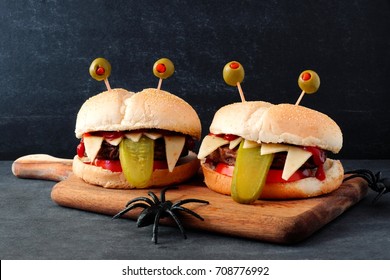 Halloween monster hamburgers on a paddle board against a black background