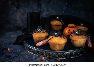 halloween muffins,spiders, bloody fingers and oranges on a tray on a dark, rusty blue background, moody, spooky, scary - Shutterstock ID 1504297589