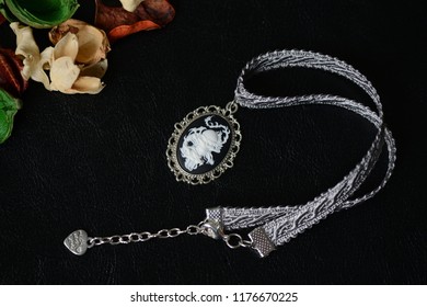 Halloween Necklace With Skull Cameo Pendant On A Dark Background Close Up