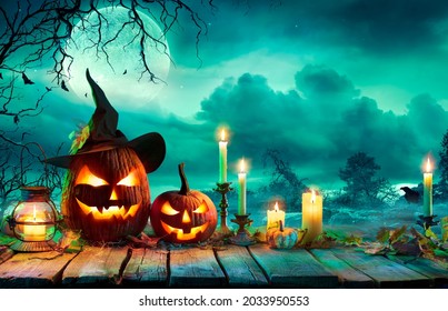 Halloween At Night - Pumpkins With Witch Hat And Candles On Table In Mystery Landscape - Powered by Shutterstock