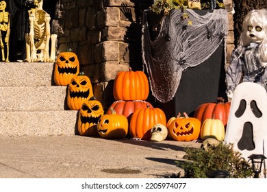 Halloween Outdoor Decorations Outside Haunted House With Pumpkins, Ghosts, Spider Webs, And Skeletons On Front Steps