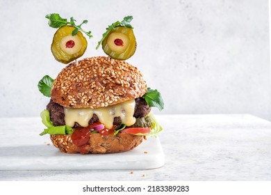 Halloween party burger in shape of scary monster. Halloween food concept. - Shutterstock ID 2183389283