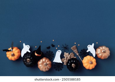 Halloween party decorations from pumpkins, bats, spider web, ghosts on dark blue background top view. Happy halloween holiday greeting card flat lay style. - Powered by Shutterstock