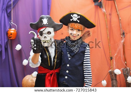 Halloween party. Two little boys in different pirate costumes with faceart are having fun at the Halloween party. Face painting kids.