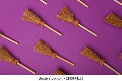 Halloween pattern with witch brooms on purple background