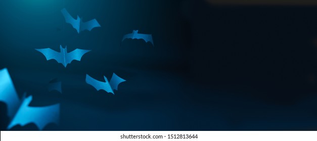 Halloween photo of blue paper bats on blank dark blue background.