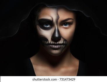 Halloween Portrait Of Young Beautiful Girl In A Black Hood. Skeleton Makeup Half Face