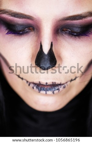 Halloween. Portrait of young beautiful girl with make-up skeleton on her face.Close up portrait of a girl in a high fashion, beauty style