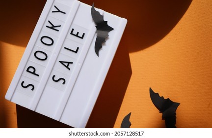 Halloween Promotion. Spooky Sale Text On Light Box. Paper Bats And Shadows 