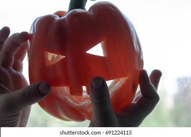 Halloween. A Pumpkin With A Carved Face Red In The Boy's Hands Against The Window. Witchcraft And Magic. Photo For Your Design