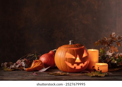 Halloween pumpkin head jack lantern with dried-up leaves. Halloween holidays art design, celebration. Carved Halloween pumpkin with burning candle. - Powered by Shutterstock