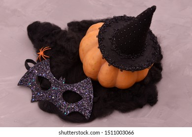 Halloween Pumpkin Head On A Gray Concrete Background. Pumpkin Head In A Bat Mask. Halloween Decoration With Pumpkins And Accessories.
