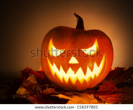 Halloween pumpkin with leafs on orange background
