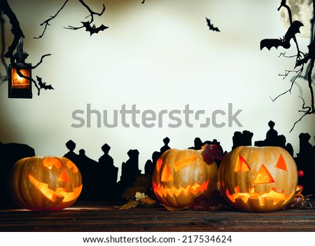 Halloween pumpkin on wooden planks. Cemetery grave stones on background