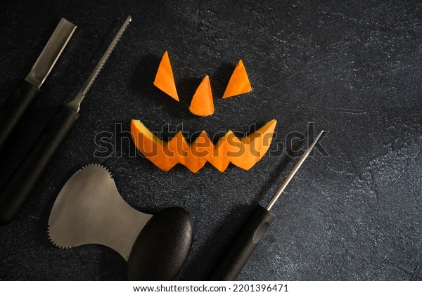 Halloween pumpkin\
pieces. Spooky laughing, scary carved Jack Lantern eyes, nose,\
mouth. Jack-o\'-lantern elements with carving tools - spoon, saw\
blade, pointed and grove\
carver.