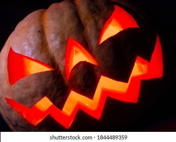 Halloween Pumpkin With Red Eyes, Scary Face And Spider On The Eye, Illuminated From Inside With Multicolored Lights, Very Scary Pumpkin For Halloween