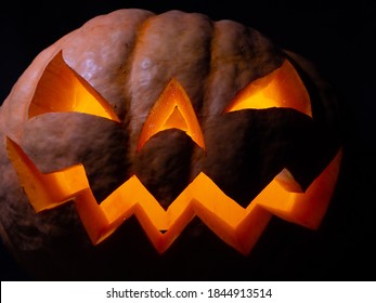 Halloween Pumpkin With Red Eyes, Scary Face And Spider On The Eye, Illuminated From Inside With Multicolored Lights, Very Scary Pumpkin For Halloween