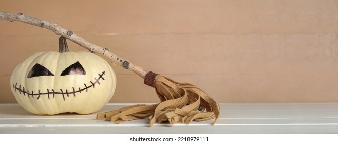 Halloween Pumpkin And Witch's Broom On Wooden Table