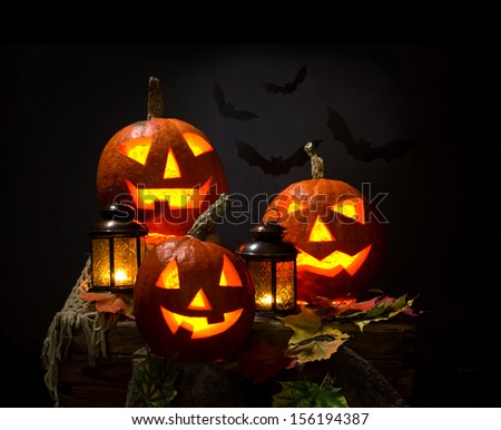 halloween pumpkins and bat with lanterns on dark background