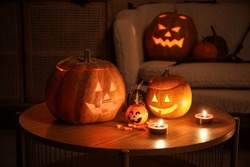 Citrouilles D'Halloween Avec Des Bonbons Et Des Bougies En Feu Sur La Table Dans Le Salon Sombre