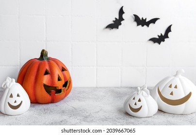 Halloween Pumpkins And Jack O Lantern Decor Against A White Wall With Bats. 