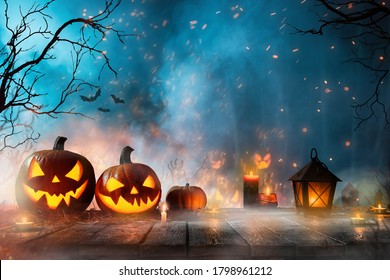 Halloween Pumpkins On Dark Spooky Forest With Blue Fog In Background.