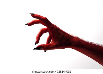 Halloween red devil monster hand with black fingernails against a plain background