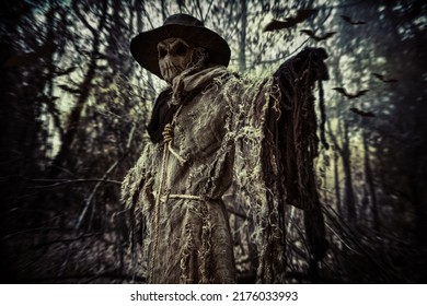 Halloween. A scene of horror, when an evil terrible Scarecrow with a bag on his head, in a sackcloth vestment and a black hat, stands in the thicket of the night forest. Horror, thriller. - Shutterstock ID 2176033993