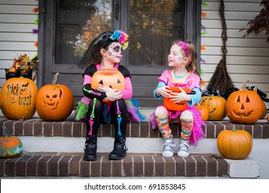 Halloween Sisters Sitting On Porch Trick Or Treating.