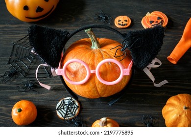 Halloween Still Life On Wooden Table, Pumpkins And Sweets On Dark Wood. Happy Orange Pumpkin With Glasses, Variety Hallowen Food And Decorations. Lifestyle, Kids Party, Fun And Halloween Concept.