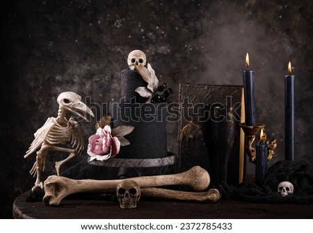 Halloween still life with skull, bones and cake