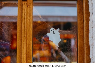 Halloween Street Decor. Paper Cut Ghost And Cobweb On Door Or Window At Store, Festive Decoration Of City Street. Happy Halloween