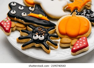 Halloween sugar cookies - pumpkin, ghosts, witch hat, spider in a plate on white background. Close up - Powered by Shutterstock