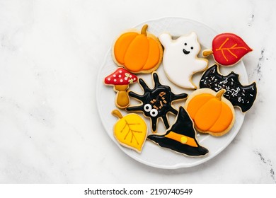 Halloween sugar cookies - pumpkin, ghosts, witch hat, spider in a plate on white background. Top view - Shutterstock ID 2190740549