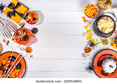 Halloween Sweets And Snacks Table. Set Of Halloween Dinner Party Foods, Candy, Snacks, With Holiday Costume Decorations, Pumpkin Buckets, Wooden Background Top View Copy Space